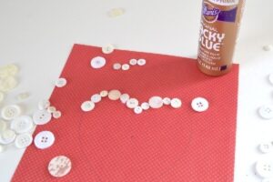 This heart button art tutorial is easy enough for kids but makes some super cute decor adults love, too! Great for home decor on a budget!