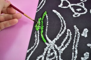 After the glue has dried mix up small amounts of watercolor paints and grab a small paint brush.