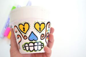 Succulents look super cute in these DIY sugar skull flower pots. Great for Halloween but colorful decor perfect for all year 'round!