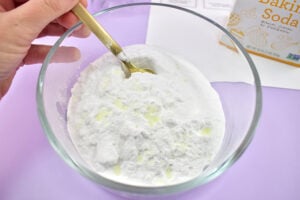 Add approximately 30 drops of essential oil or fragrance oil to the baking soda. Use a fork to combine until well mixed.