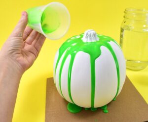 These colorful, drippy no carve pour art pumpkins are super easy and use washable paint making it the perfect Halloween kid craft! Click through for a few tips and tricks so you can achieve pretty results!