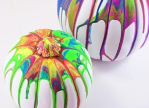 These colorful, drippy no carve pour art pumpkins are super easy and use washable paint making it the perfect Halloween kid craft! Click through for a few tips and tricks so you can achieve pretty results!