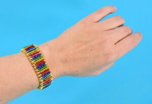 Can you believe this colorful bracelet is made out of safety pins? No jewelry making tools needed to make this fabulous rainbow beaded safety pin bracelet!