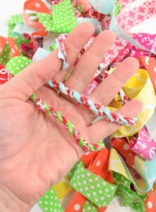 Learn how to turn your scrap material into simple and adorable fabric twine. Make something cute and bust your craft stash at the same time!