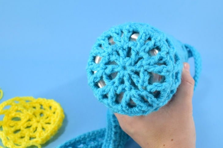 Hate holding on to your water bottle? This crochet water bottle holder is a great use of scrap yarn and it keeps your water nearby and your hands free!