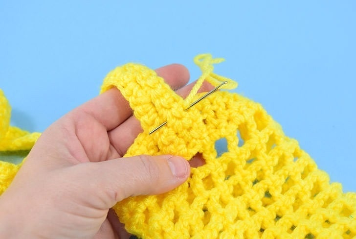Hate holding on to your water bottle? This crochet water bottle holder is a great use of scrap yarn and it keeps your water nearby and your hands free!