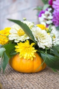 Grab a mini pumpkin & a bouquet of fresh fall flowers & turn them into some amazing arrangements in fresh pumpkin vases that your guests will adore!
