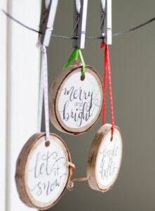 Grab our FREE pattern and add a little rustic flair to your Christmas decor with these easy to make, hand-lettered wood slice Christmas ornaments!