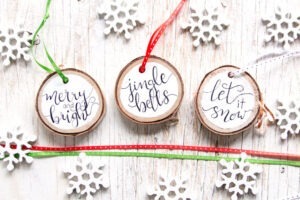 Grab our FREE pattern and add a little rustic flair to your Christmas decor with these easy to make, hand-lettered wood slice Christmas ornaments!