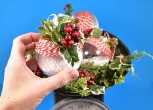 Craft supplies from the bargain bin become simple yet gorgeous baker's twine and holly rustic Christmas ornaments you can make in only 5 minutes apiece!