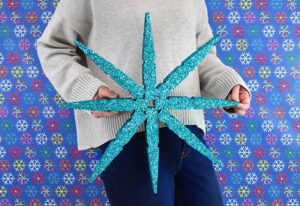 Absolutely massive clothespins make the most perfect, 20 inch giant clothespin snowflakes that will be the glittery envy of all of your holiday guests!