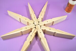 Absolutely massive clothespins make the most perfect, 20 inch giant clothespin snowflakes that will be the glittery envy of all of your holiday guests!