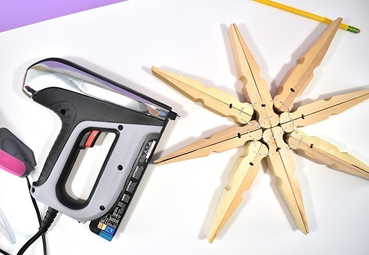 Absolutely massive clothespins make the most perfect, 20 inch giant clothespin snowflakes that will be the glittery envy of all of your holiday guests!