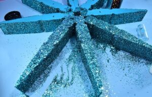 Absolutely massive clothespins make the most perfect, 20 inch giant clothespin snowflakes that will be the glittery envy of all of your holiday guests!