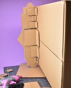 Don't you just love this "hissing booth" cardboard cat hideaway? All you need is a moving box and some cardstock to make this adorable kitty play place.