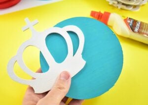 Glue one wood crown onto the flat side of each wooden plaque.