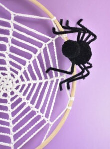 Turn embroidery hoops into adorable Halloween decor by adding crochet spider webs to them. Add in some pompom spiders and it's almost too cute!