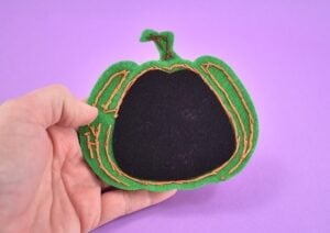 Seat the black felt piece inside of the sewn jack-o-lantern cat toy face.