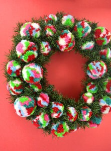 Want to add a little bit of color to your otherwise traditional Christmas decor? This pine and pompom wreath is gorgeous, easy and inexpensive!