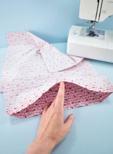Keeping the piece of fabric folded, you should now have 2 clean sewn edges. To turn this into a pillowcase, we're simply going to sew down the long sides.