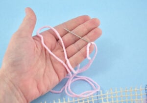 Thread a yarn needle with yarn matching your project colors.