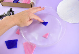 Decide which side is the smoothest and has the least imperfections. Place that piece pretty side down onto the shelf liner. Press firmly in place to prevent cement from covering the glass.