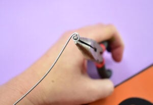 Trim a piece of steel wire to a piece of approximately 8" long. Wrap the wire around the tip of a pair of needle nose pliers to form a spiral.