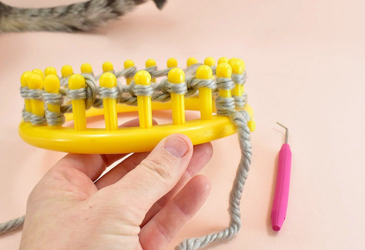Continue pulling the bottom loops over the top and off of the peg for around, working counter-clockwise until you return to the first peg.
