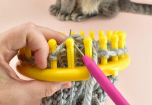Use your loom knitting tool to pull all of the loops off of the loom.