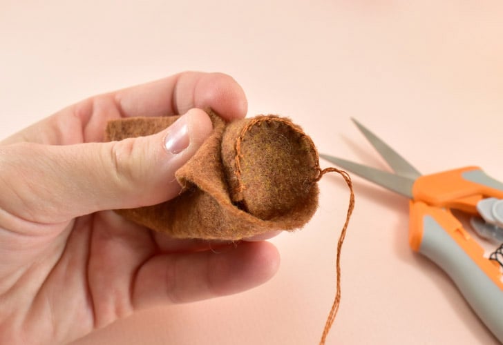 When you get to the point where the felt will overlap itself round the stem, trim the excess. Stitch together the gap to the end. Leave a tail of embroidery floss of 6-8".