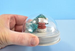 It's a good idea to make sure that your mini ornaments will fit inside of the globe before any glue is introduced. Bottle brushes can be trimmed down to the right size using a wire cutters. More solid ornaments will need to fit from the get go.