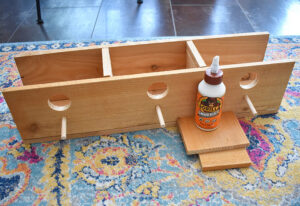 Glue the board with perches into place as seen here. Add 3 screws from the bottom to hold in place.