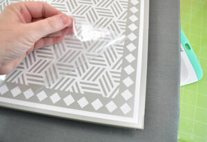 As you've adhered sections very carefully pull up the carrier sheet. Any vinyl that comes away with the carrier sheet or bubbles up from the metal will need more heat. If you have an EasyPress Mini this is the perfect time to use it! Don't over apply heat as much as possible. Too much heat to areas that are already adhered can make the adhesive seep from behind the design making it not stick properly.