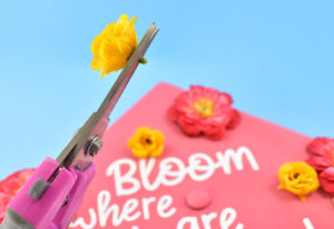 Remove the flower or stem from the metal wire stem." Trim the excess plastic away from the back, as much as possible, so that it will lay down flat on the cap.