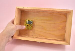 Place the mechanism inside of the jewelry box, aligning the screw holes.