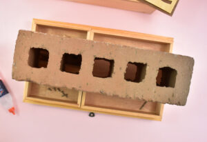 If using a glue that takes a while to dry, it's advisable to place the interior trays onto the veneer to hold it down. Just make sure there isn't any glue on the top of the design, or squeezing out that will make the veneer glue to the bottom of the trays. Apply weight on top of the trays to help keep the smaller veneer pieces in place as the glue dries.