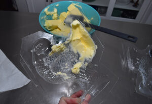 Using a spoon, rubber spatula, or a butter knife spread a thin layer of butter into the mold. Take care to push the butter into all of the nooks and crannies.