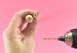 Using a 5/64" Wood Drill Bit drill a hole through the cap of the dowel end and a shallow hole in the center of one end of your 48" wood dowel. Go for center but don't stress. If they are slightly off you won't notice it in the end.