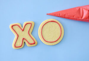 Draw an outline of the shape of the cookie in the center of each X and O. Set aside and allow the icing 1-2 minutes to begin drying.