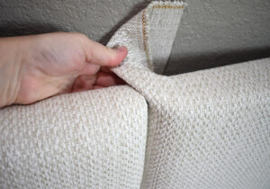 Pull the first corner over onto the panel it buts up against and staple into place using 3/8" staples. Pull the second corner from over the first.