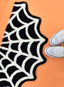 A little bit spooky and a whole lot cute, grab the free pattern to make your own Spiderweb Punch Needle Rug!