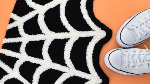 A little bit spooky and a whole lot cute, grab the free pattern to make your own Spiderweb Punch Needle Rug!