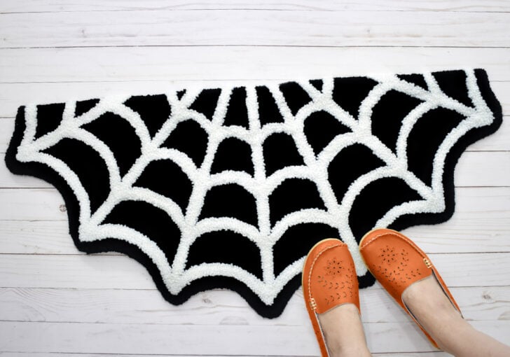 A little bit spooky and a whole lot cute, grab the free pattern to make your own Spiderweb Punch Needle Rug!