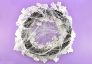 Cover both the front and back with thin wisps of spiderwebs, going a bit heavier on the front side around clumps of white berries.