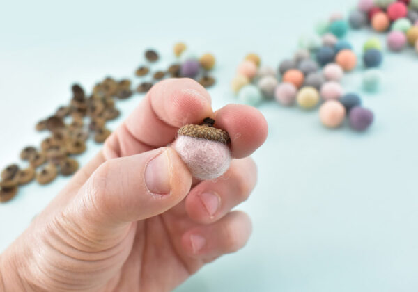 Push the felt ball into the cap and twist to spread around the glue. Push the felt ball into the cap until it can hold on its own.