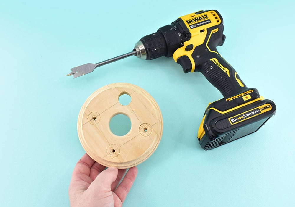 Change to your 3/4" spade drill bit. Place the center point of the bit into the holes you pre-drilled to mark the correct placement. Hold the drill nice and straight and drill all the way through each. 
