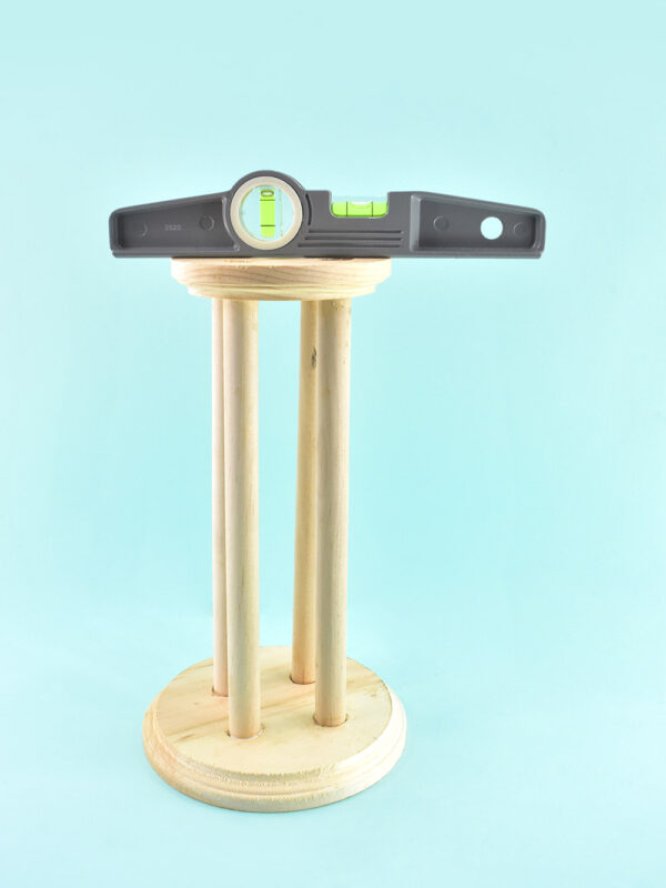 So all of your dowels are flush but sometimes woodworking is kind of funny and maybe your stand isn't actually level. Place a level on the top of the stand and gently push up or down on the top round until the level reads as level. Twist the stand around and around leveling as needed until it works all of the way around.