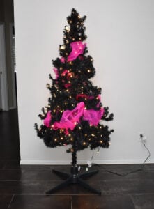 Plug in and run the hot pink LED lights through the tree and around. There is nothing perfect about the shape, you just need something that coils around the tree once or twice. Go over top of the lights with the hot pink deco mesh. Push it into the tree and bubble it out in other areas for an attractive look.